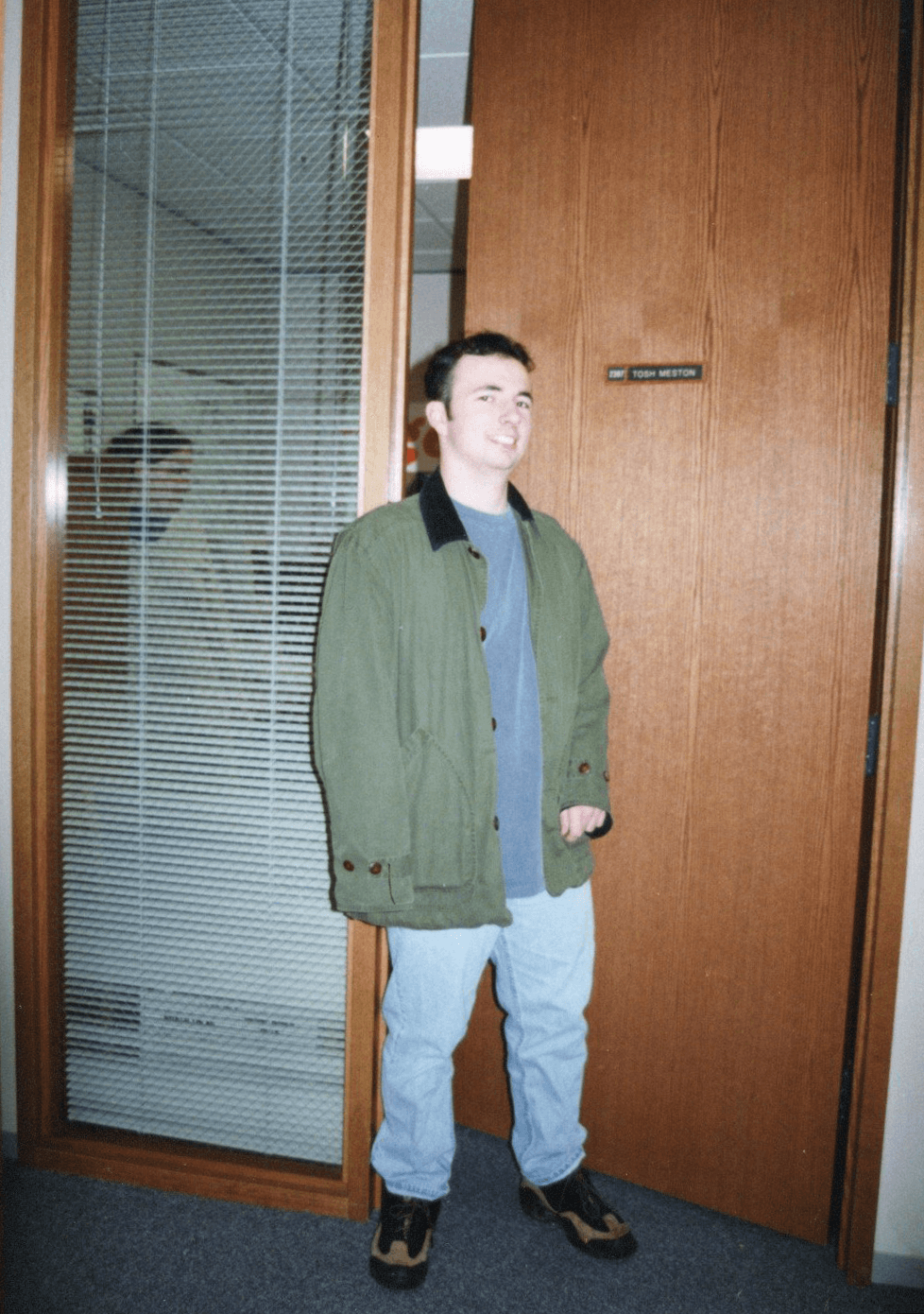 Tosh Meston standing beside his Microsoft office door in 1996